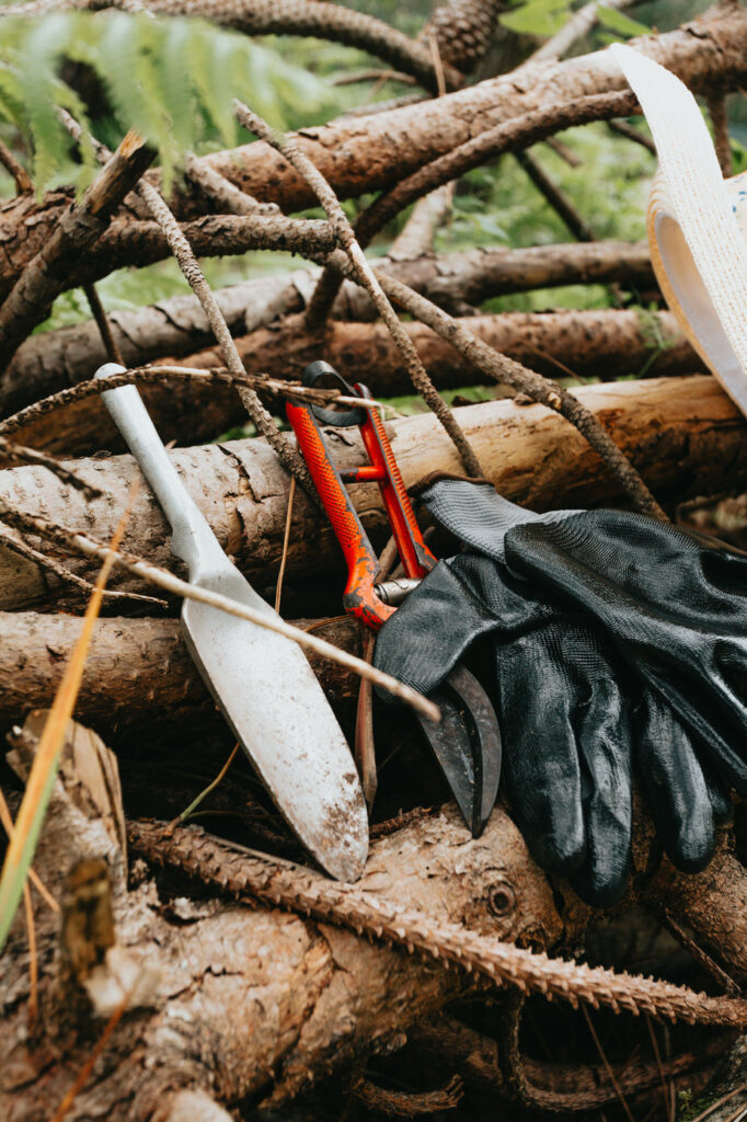 Gardening Tools Leaning Against A Pile Of Wooden Sticks 682x1024
